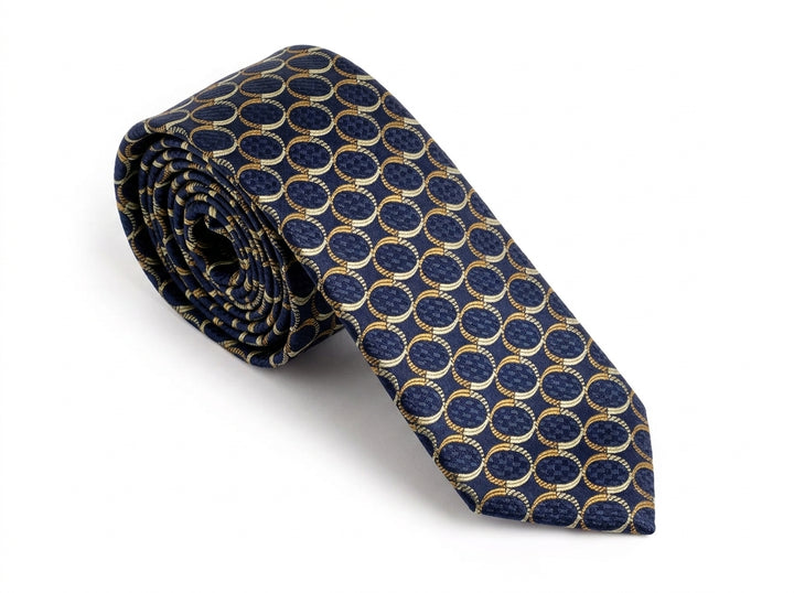 A rolled-up necktie featuring a repeating pattern of interlocking gold rings on a textured navy blue background, set against a plain white studio backdrop.