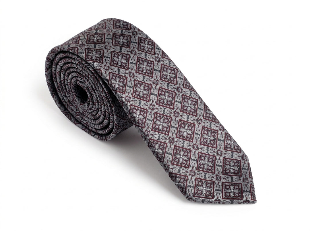 A rolled necktie with a repeating geometric pattern in gray, burgundy, and white, displayed on a clean white background.