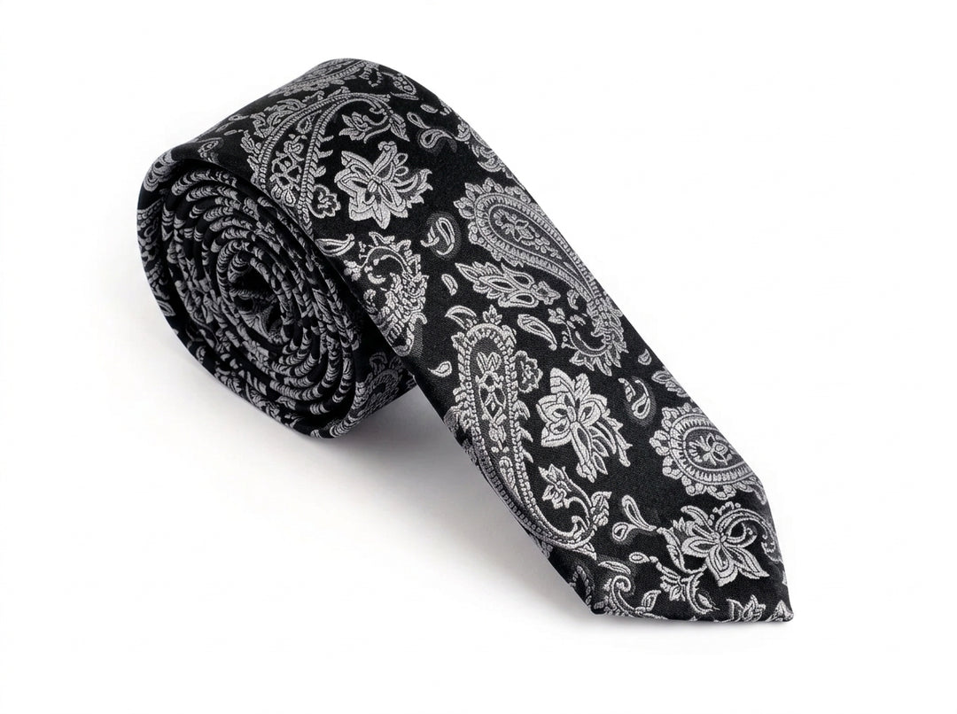 A rolled-up necktie with a black and white paisley pattern, displayed on a clean white background.
