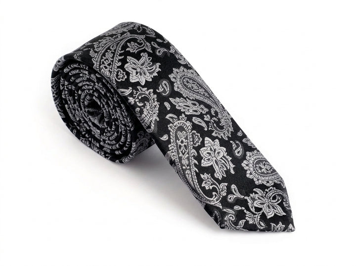 A rolled-up necktie with a black and white paisley pattern, displayed on a clean white background.