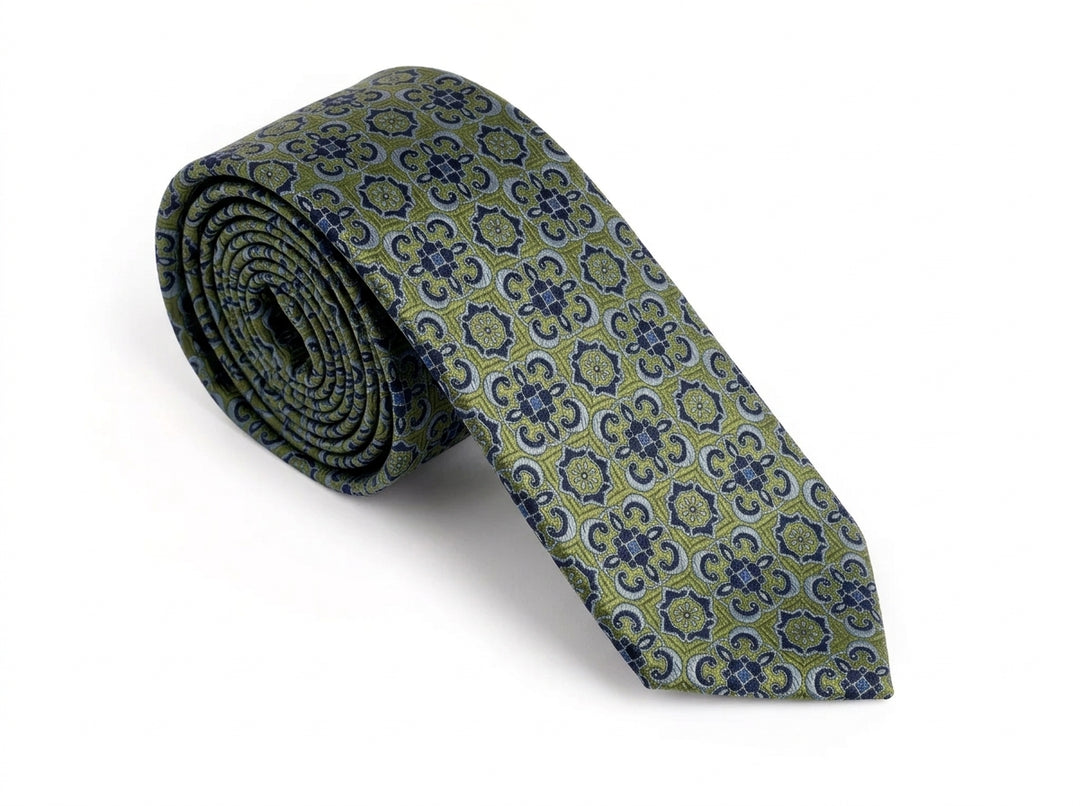 A rolled necktie with an intricate geometric and floral pattern in olive green, navy blue, and light gray, displayed on a clean white background.
