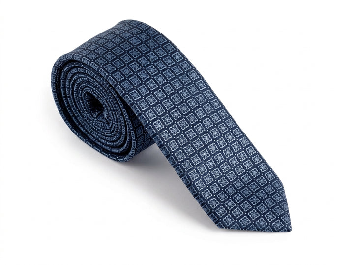 A rolled navy blue necktie with a repeating small light blue geometric pattern, displayed on a clean white background.