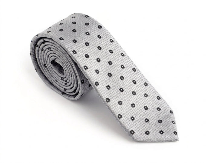 A light gray silk necktie with a repeating pattern of small black embroidered dots, rolled up and displayed on a clean white background.