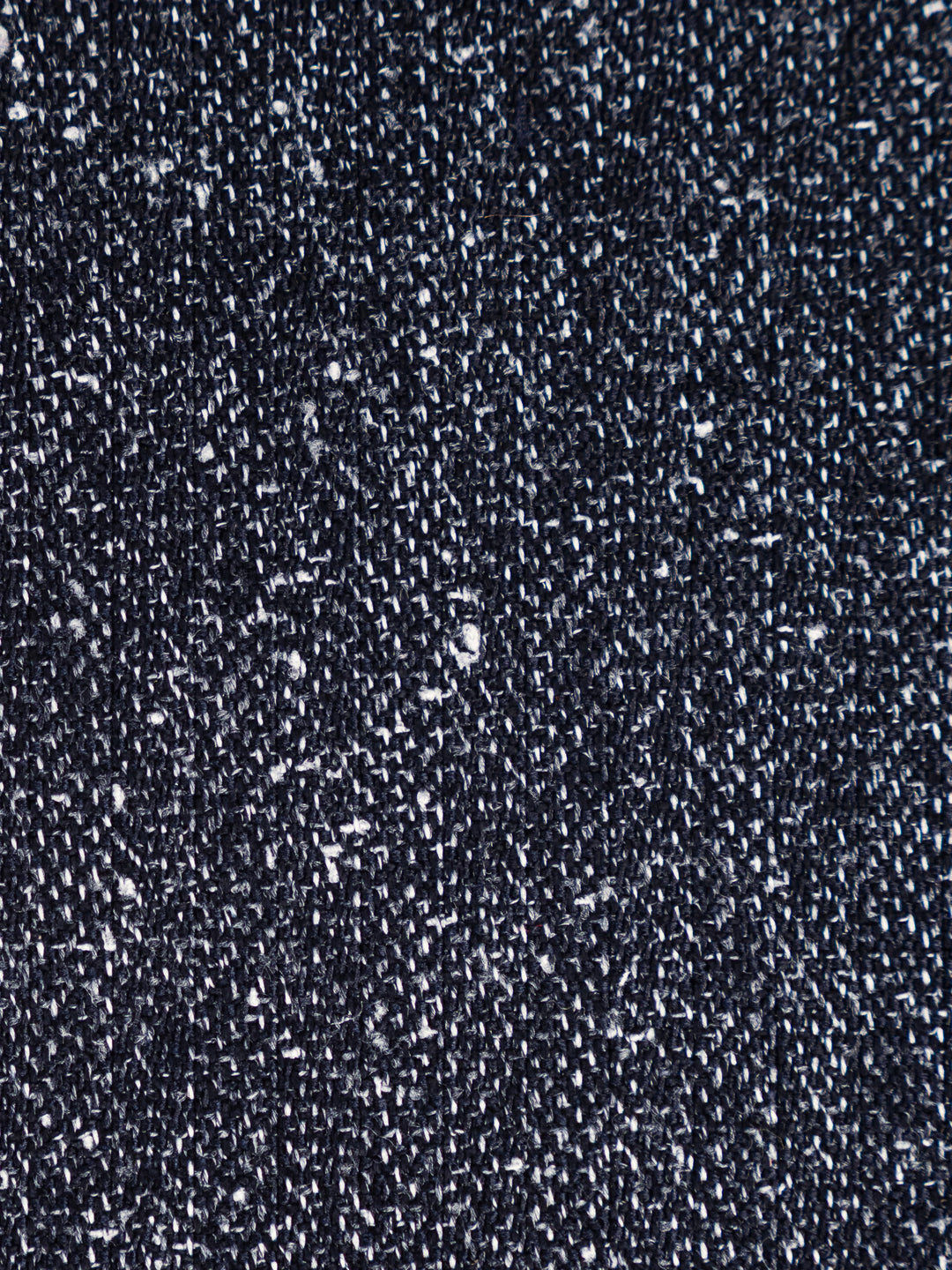 A close-up texture shot of a dark navy blue woven fabric with white flecks throughout, showing the detailed knit or woven pattern.