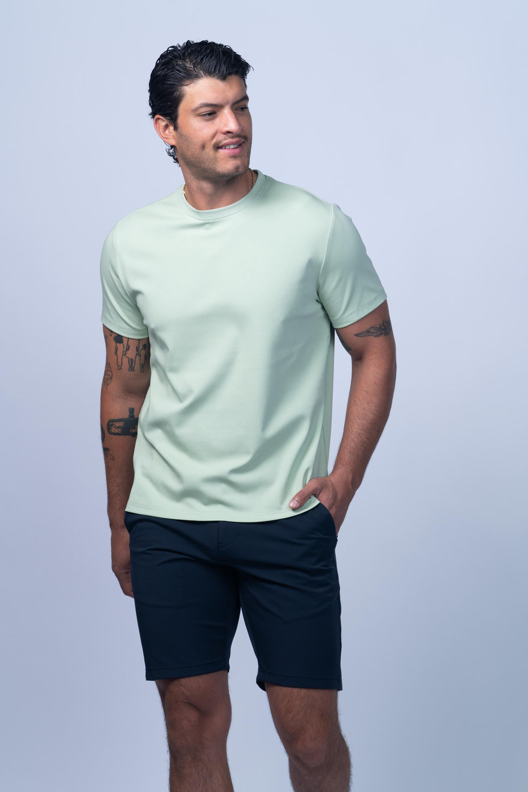 Man wearing a light green t-shirt and navy shorts