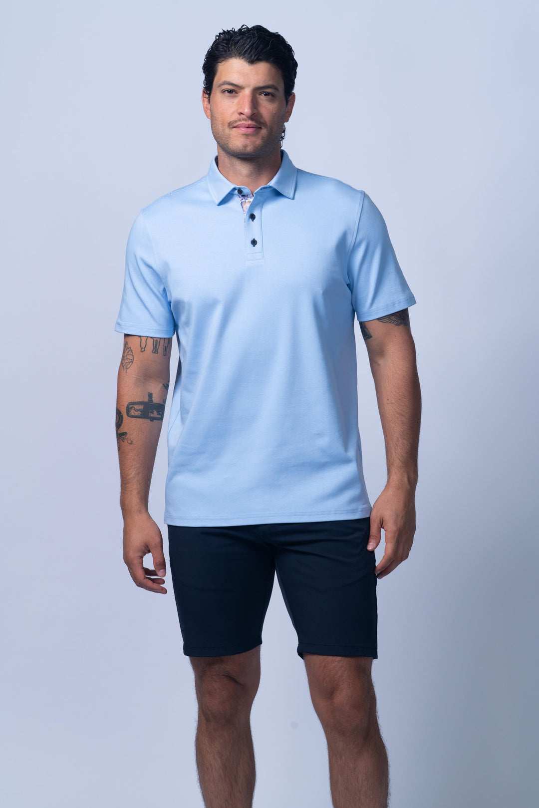 Man wearing a light blue polo shirt and dark shorts