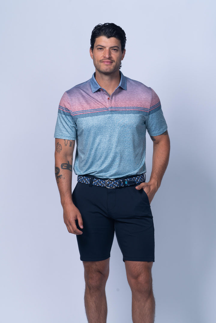 Man wearing a blue and pink striped polo shirt and navy shorts on a white background