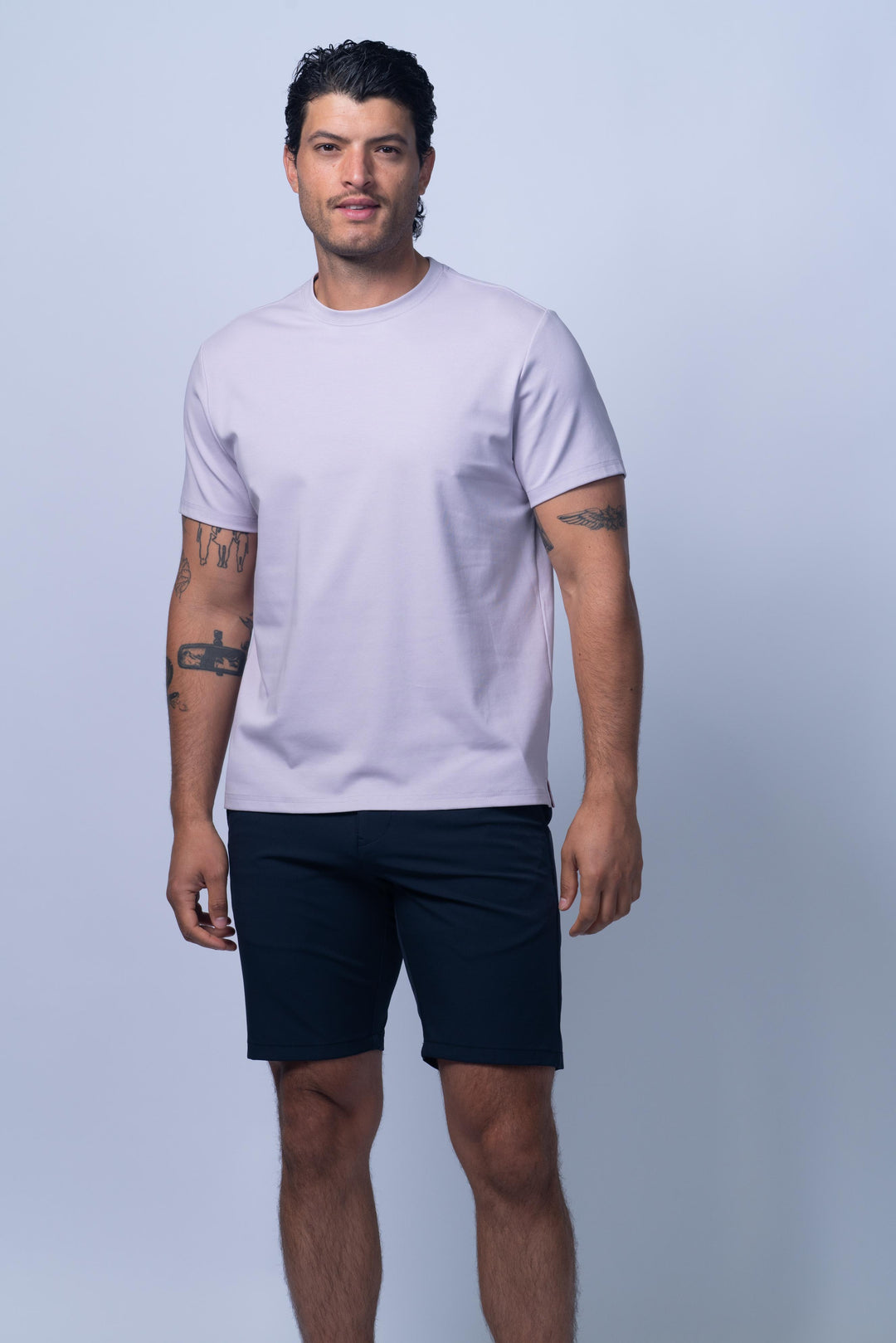 Man wearing a light purple t-shirt and navy shorts