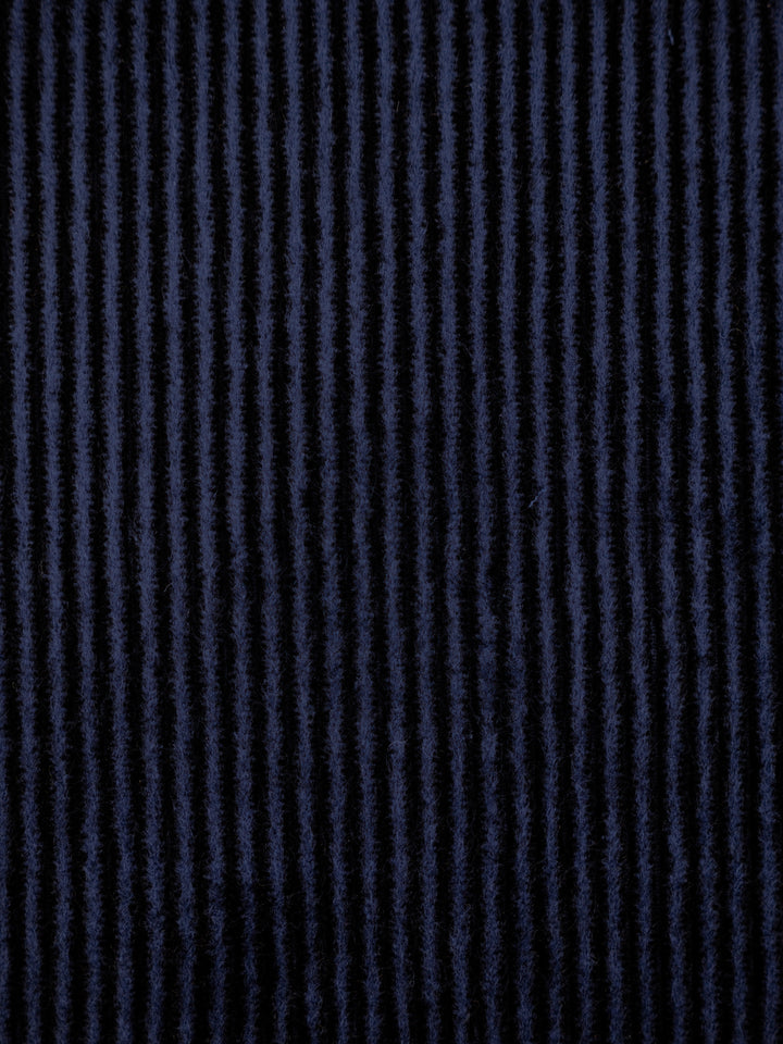 A close-up of a dark navy blue fabric with vertical textured stripes.