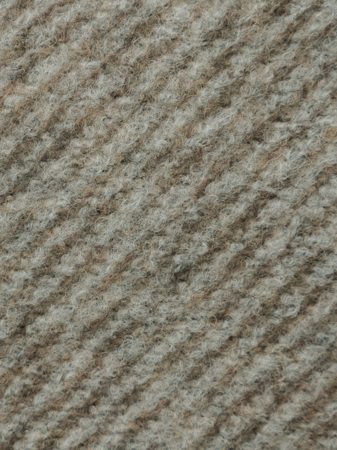 A close-up texture shot of a heathered wool fabric with a diagonal ribbed pattern in a blend of taupe, beige, and light gray.