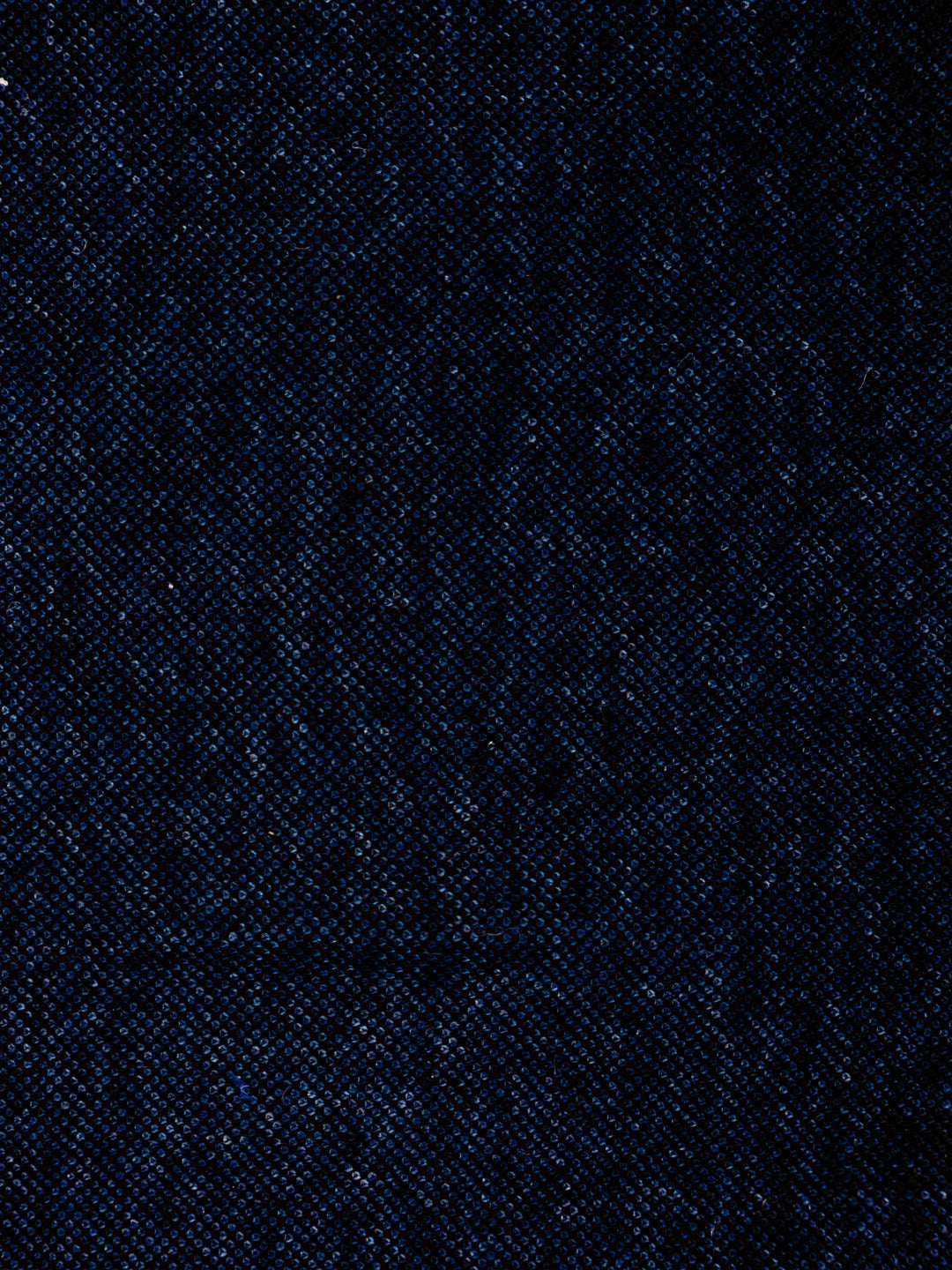 A close-up of dark navy blue textured fabric with a fine woven pattern.