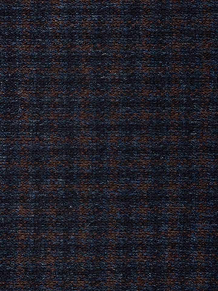 A close-up of a textured woven fabric with a dark navy blue and brown houndstooth pattern.
