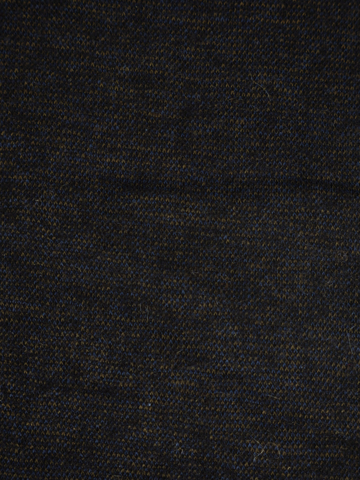 A close-up of a dark woven fabric texture, appearing as a very dark navy or black material with subtle blue and warm brown threads.