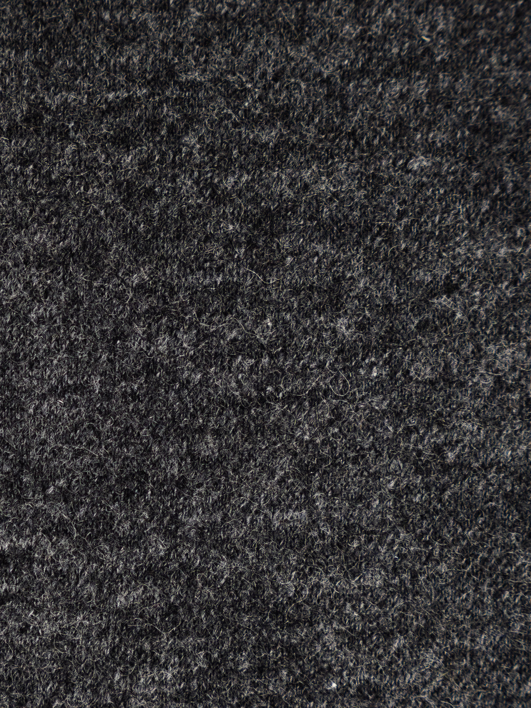 A close-up texture shot of a dark charcoal gray felt or wool fabric, showing the dense, fibrous surface detail.