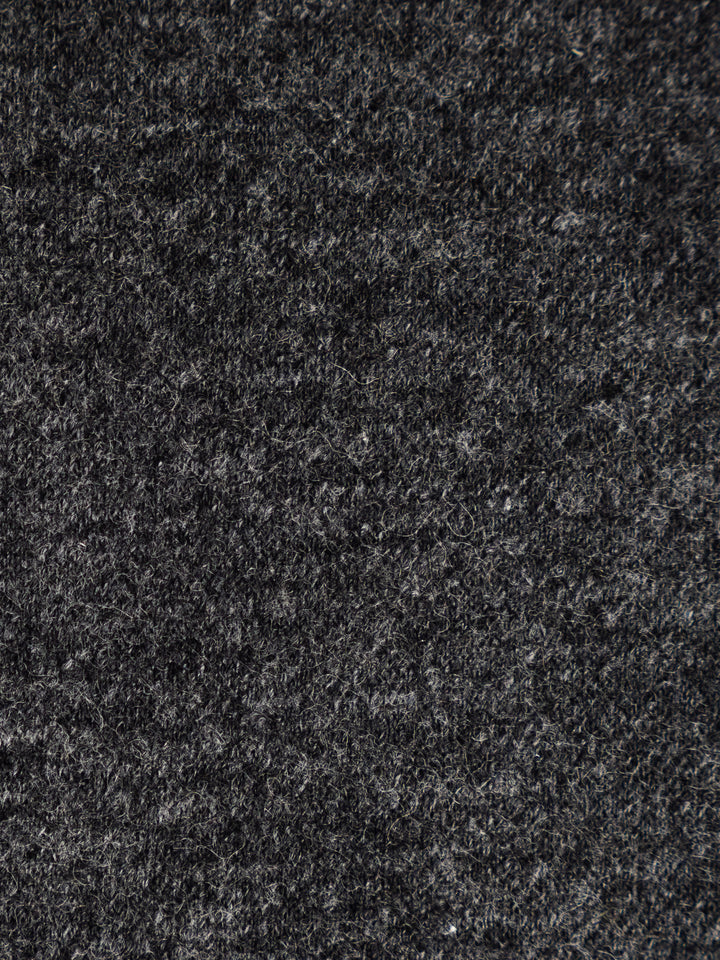 A close-up texture shot of a dark charcoal gray felt or wool fabric, showing the dense, fibrous surface detail.