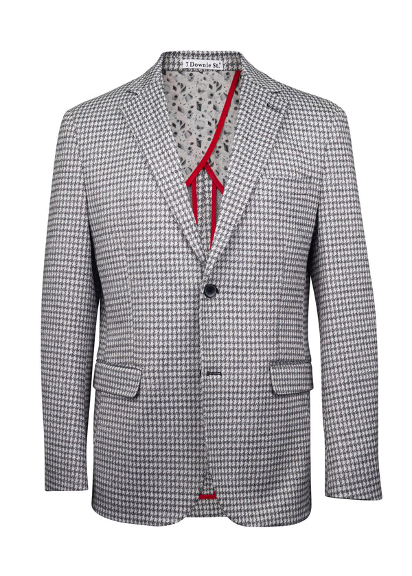 A men's single-breasted blazer with a small-scale black and white micro-houndstooth pattern, featuring a red self-tie neck ribbon and a patterned lining visible inside the collar.