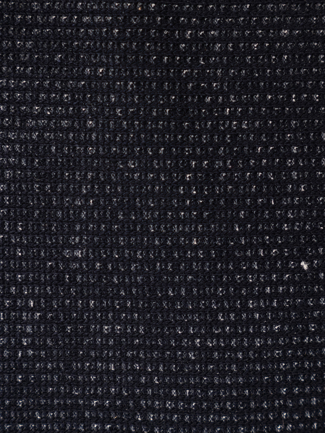 A close-up texture shot of a dark charcoal gray woven fabric, showing a detailed ribbed or waffle-like knit pattern.