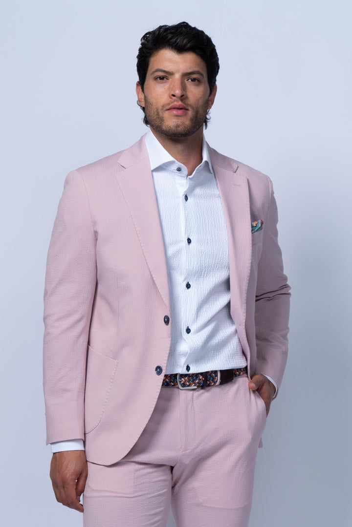Man wearing a light pink suit with a white shirt