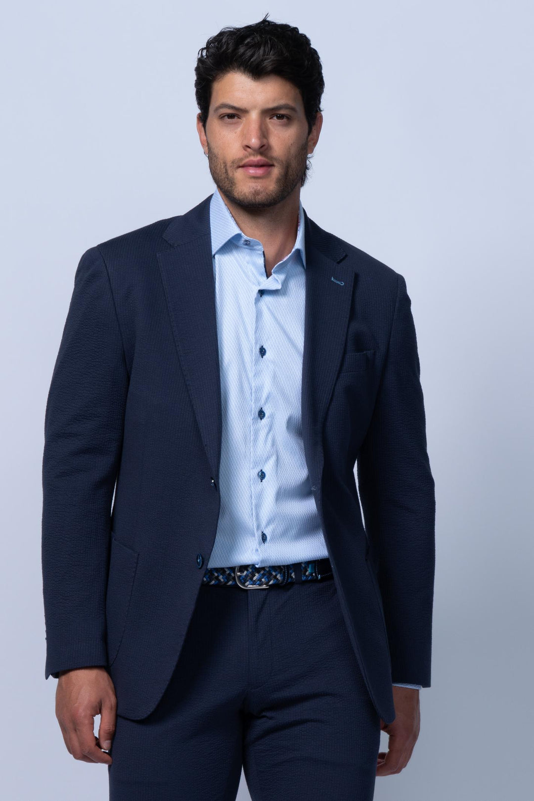 Man wearing a navy suit with a light blue shirt 