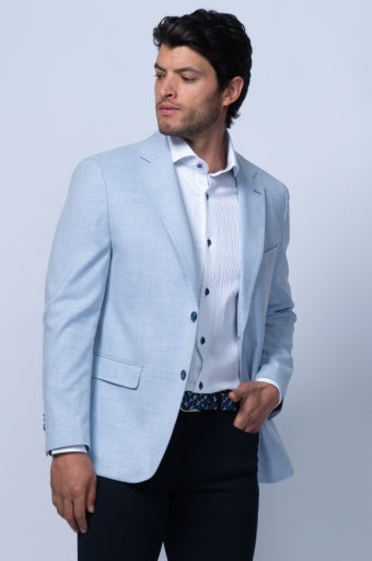 Light blue tailored blazer with notch lapel, worn over a white shirt and dark trousers. Features two front pockets.