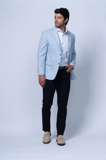 Light blue tailored blazer worn over a white shirt with dark trousers, showcasing its structured design.