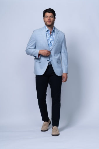 Light blue tailored blazer worn over a patterned shirt, paired with dark trousers, showcasing its structured fit.