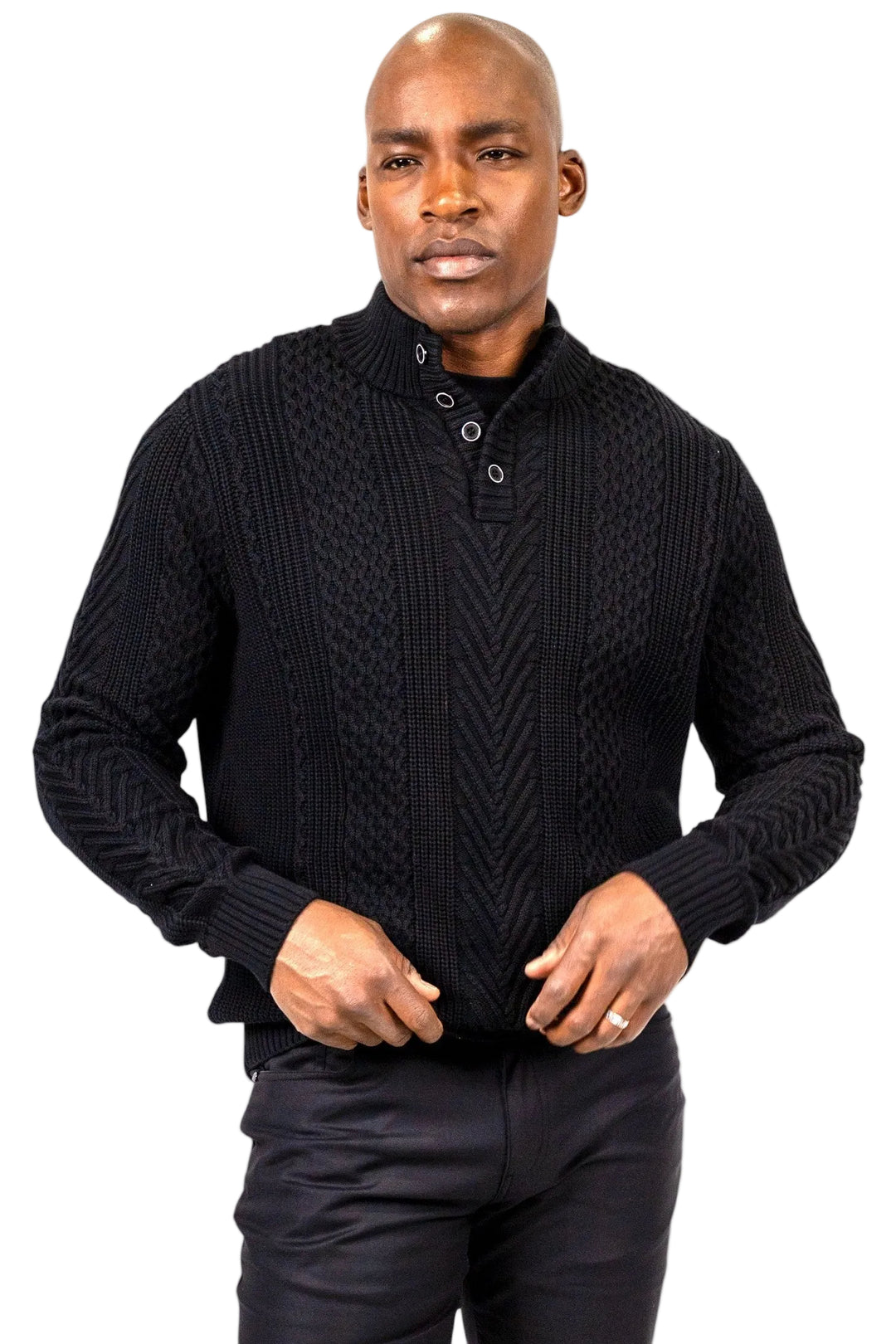 A man wearing a black textured knit long-sleeve henley sweater with a stand collar and button placket, paired with black trousers, against a plain white background.