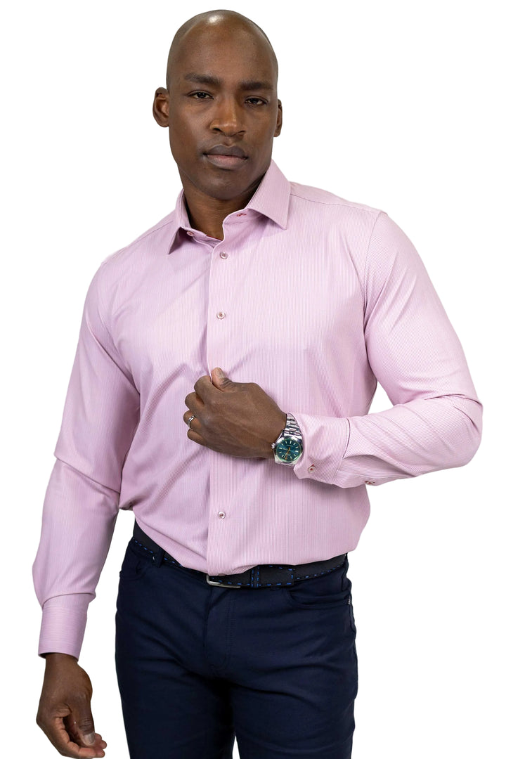 A man wearing a light pink long-sleeve dress shirt and navy blue trousers, standing against a plain white background.