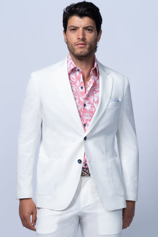 Man wearing a white suit with a patterned shirt